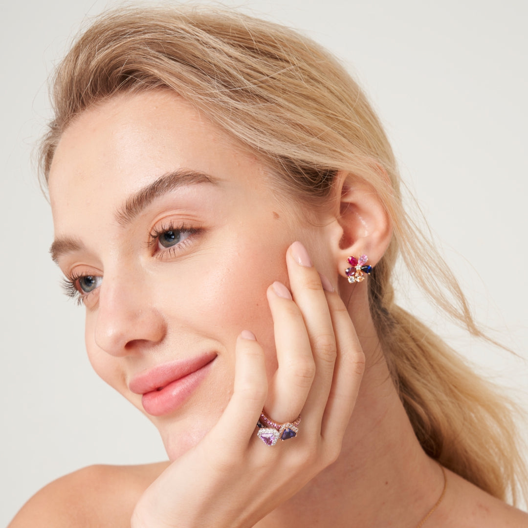 A model wearing Florea flower floral earrings set with lab grown Diamonds, Blue sapphire, Pink sapphire and Champagne sapphire gem stones.