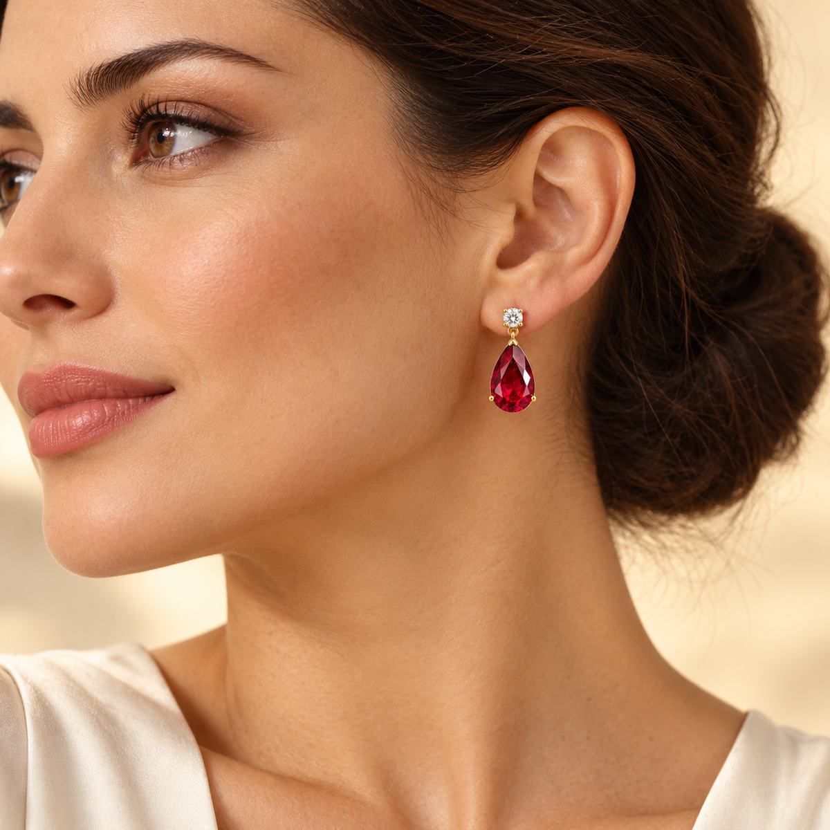 Model wearing large lab-grown ruby and diamond pear drop earrings in gold | Pisa by Juvetti