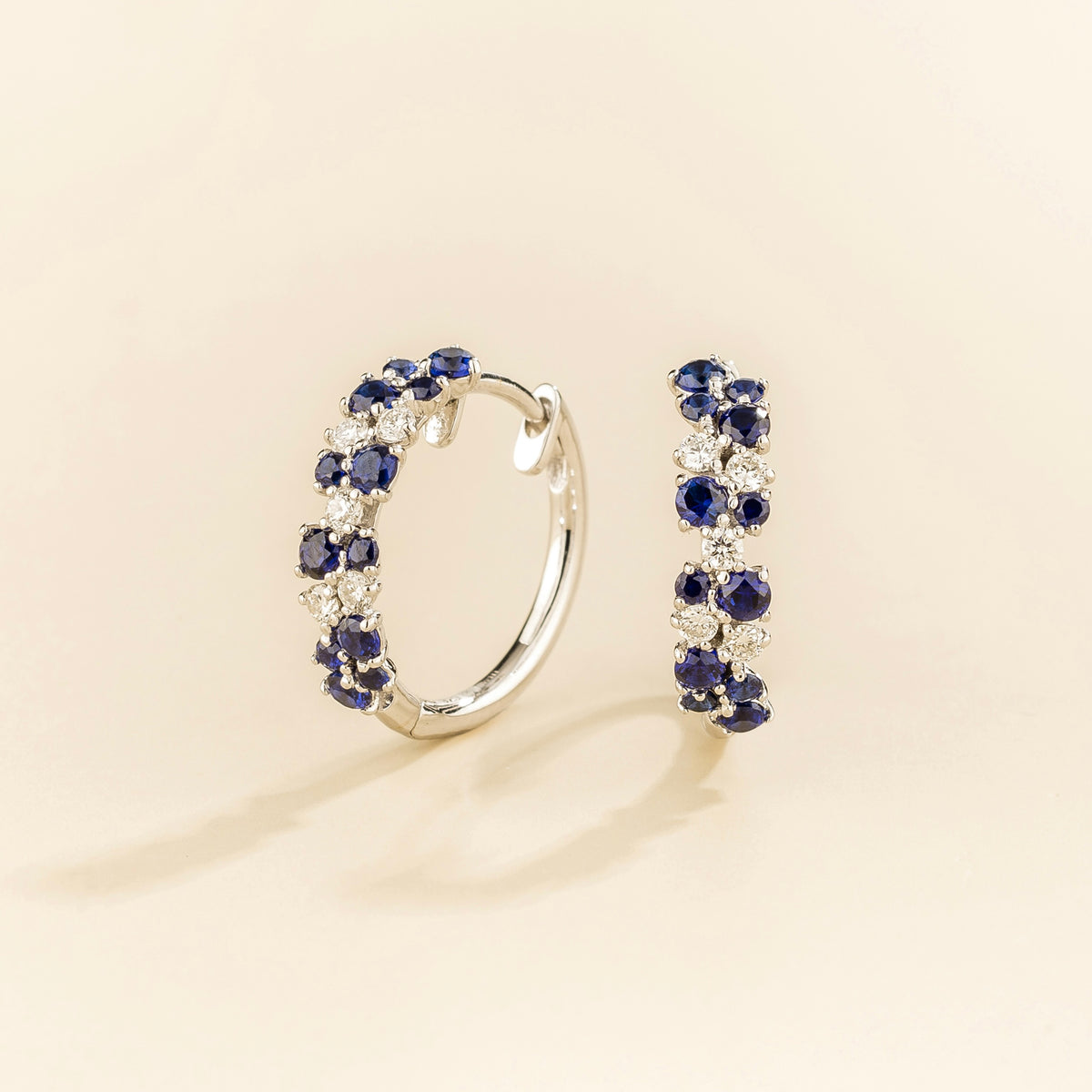 Starry blue sapphire & diamond cluster huggie hoop earrings in white gold