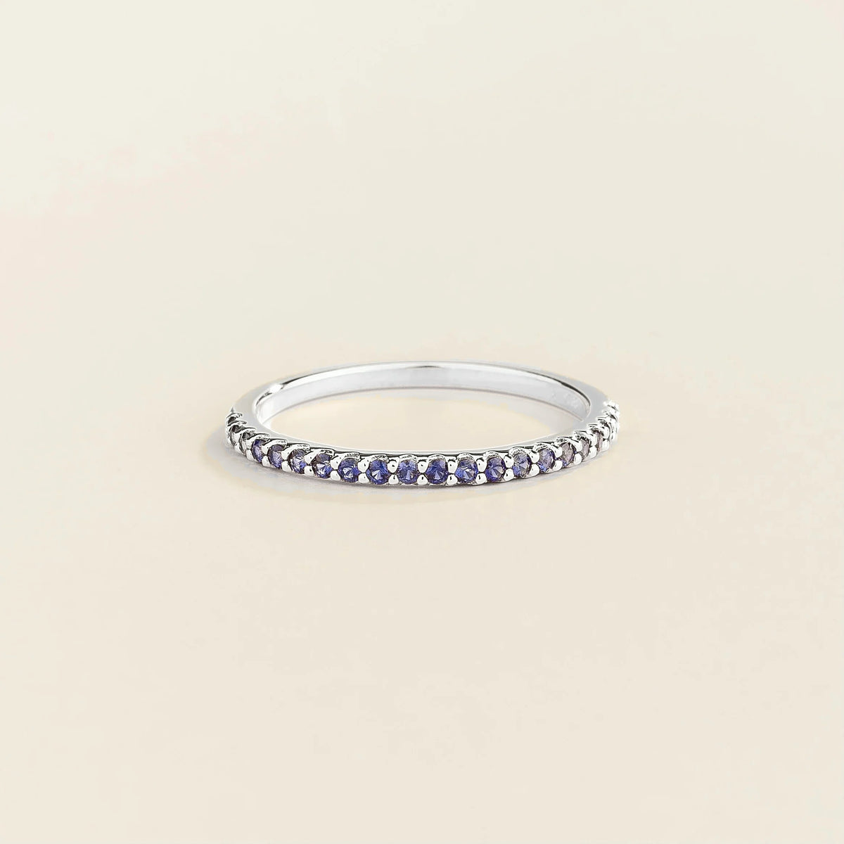 Juvetti white gold half eternity band set with round lab-grown blue sapphire gemstones.