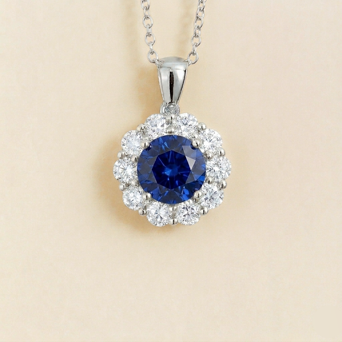 Floret round lab-grown blue sapphire and diamond halo pendant necklace in white gold – front | Juvetti London