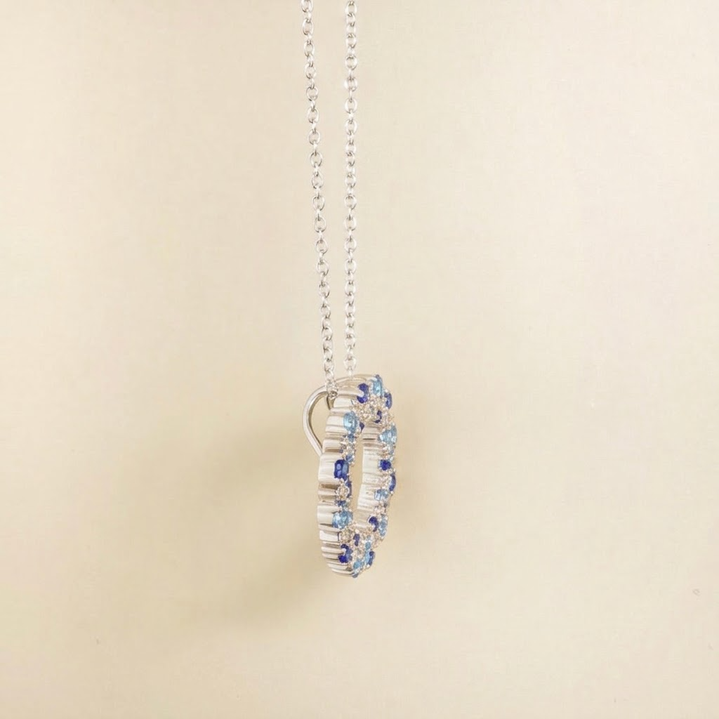 Starry blue sapphire and diamond eternity circle pendant necklace in white gold, side view