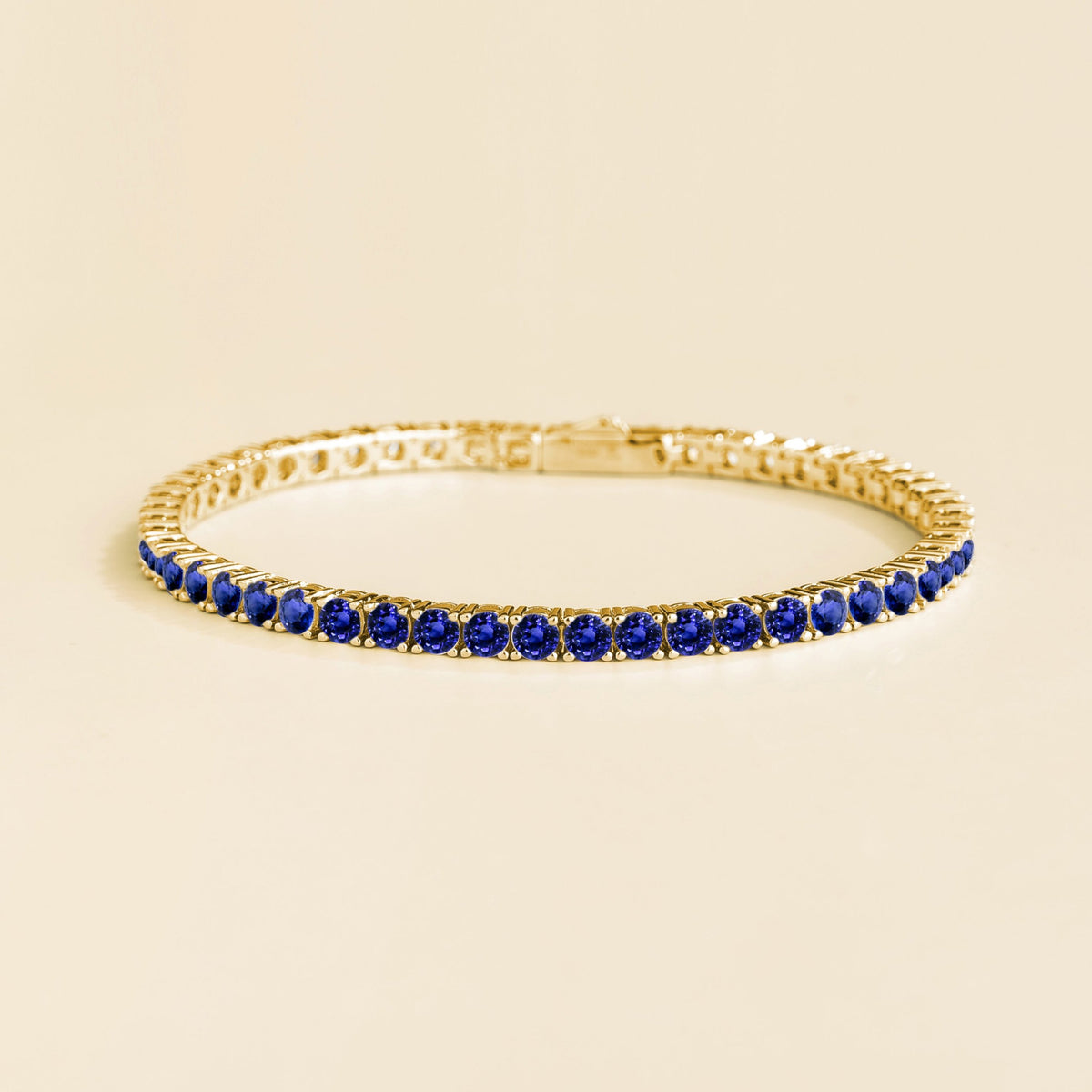 Round blue sapphire tennis bracelet set in gold