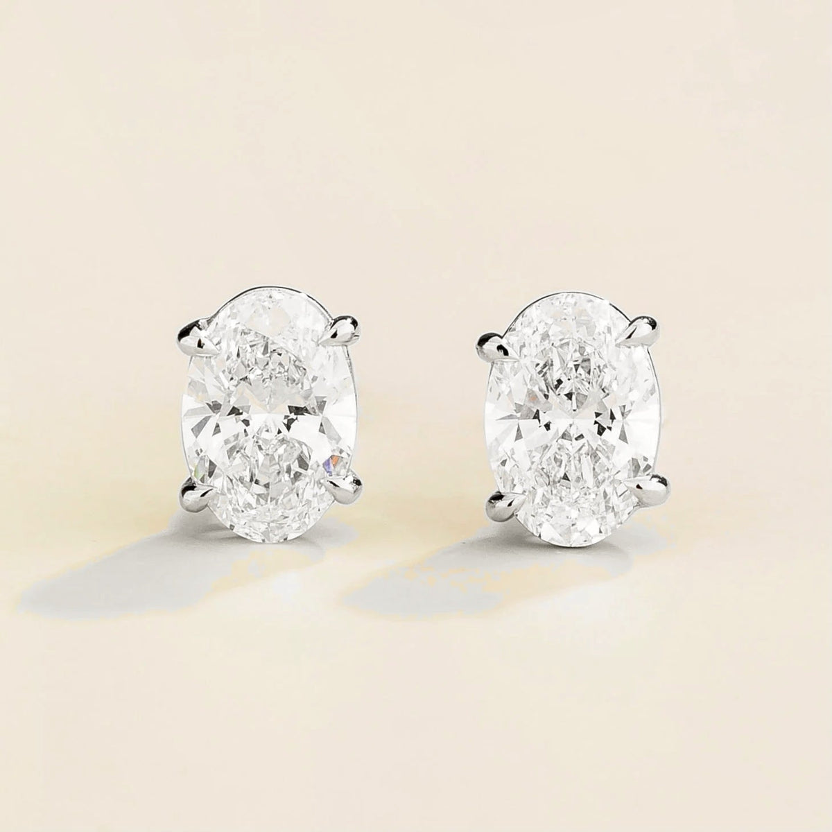 Ovo diamond oval solitaire stud earrings in white gold