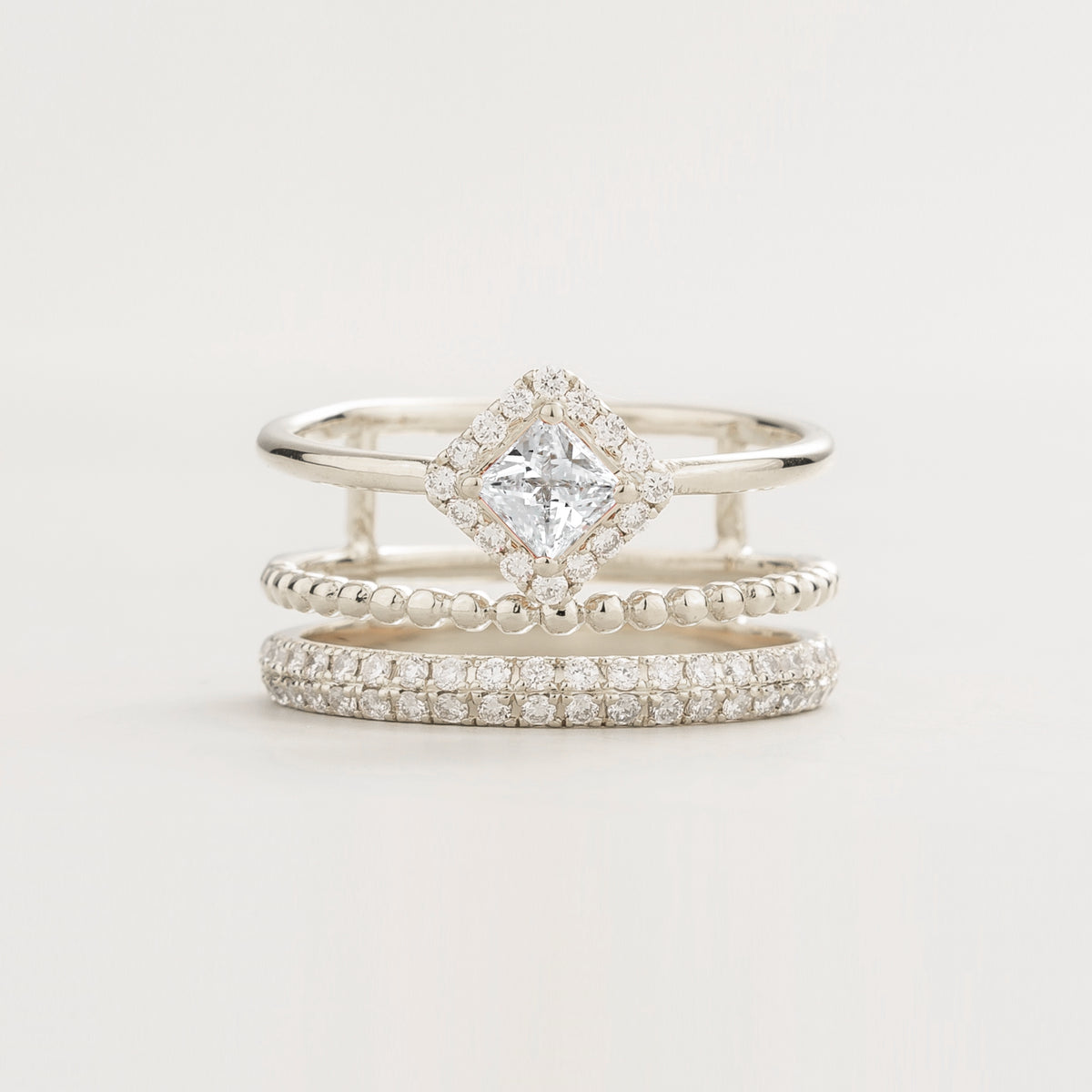 Amici triple-band stacking ring in white gold, princess-cut lab-grown diamond in a diamond halo with beaded and pavé bands, front view | Juvetti London