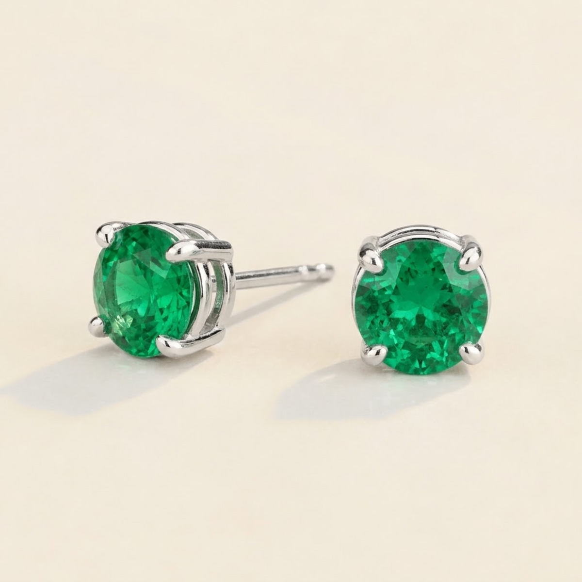 Nina round lab-grown emerald solitaire stud earrings in white gold – angled view | Juvetti London