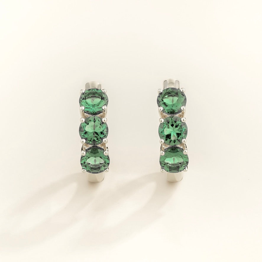 Tres Emerald Three-Stone Huggie Hoop Earrings in White Gold – close-up