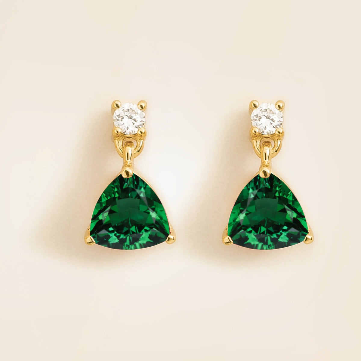 gold drop earrings set with trillion emerald and diamonds