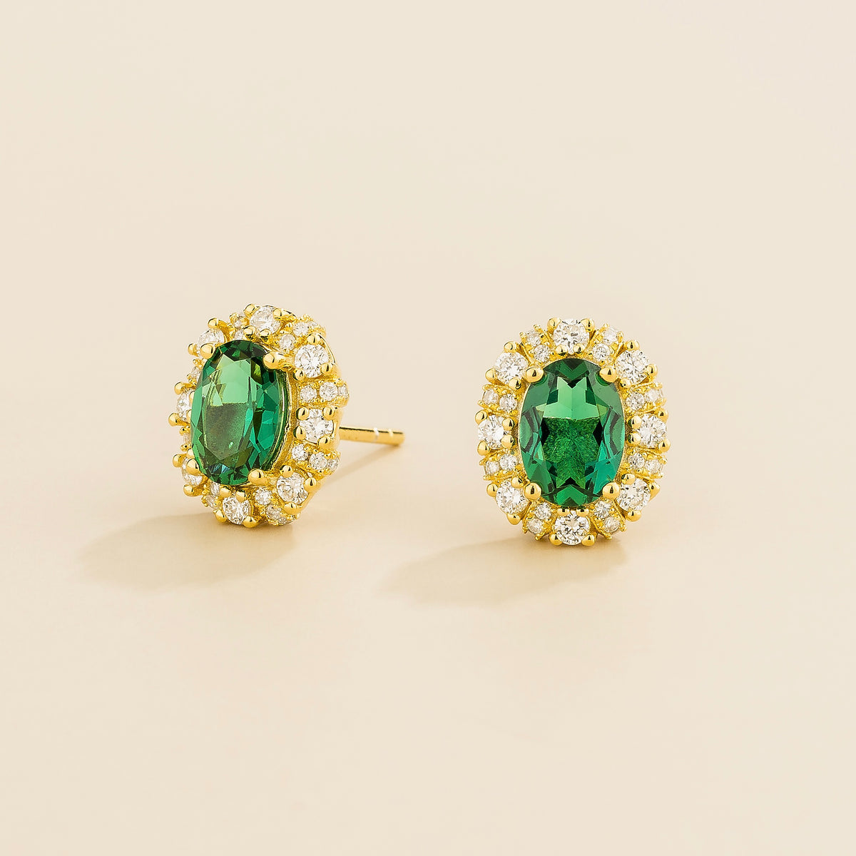 Viva oval emerald and diamond halo stud earrings in gold – angle view