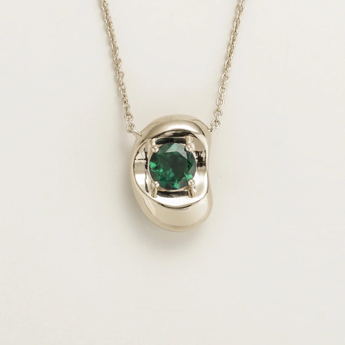 Fava round lab-grown emerald pendant necklace in white gold, sculpted pebble setting, front view | Juvetti London