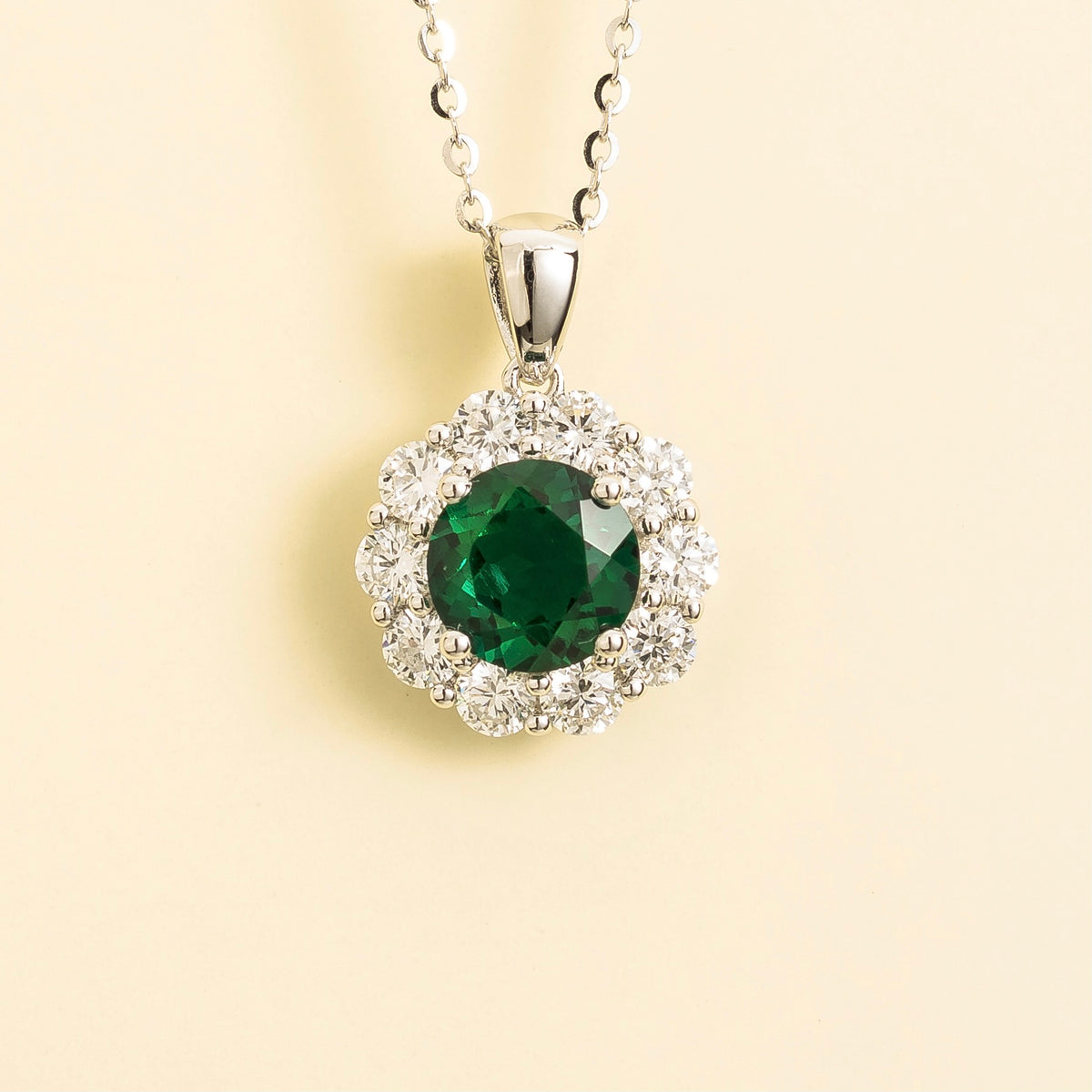 Floret round lab-grown emerald and diamond halo pendant necklace in white gold – front | Juvetti London
