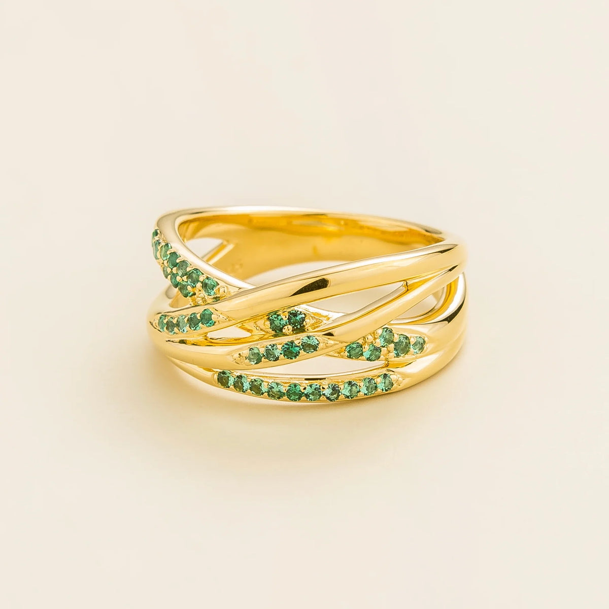 Val multi-row crossover band ring with lab-grown emeralds in gold – angle view | Juvetti London