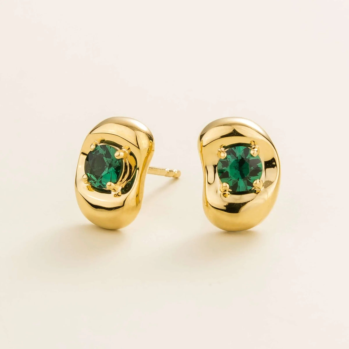 Fava round lab-grown emerald stud earrings in gold, sculpted pebble setting, angled view | Juvetti London