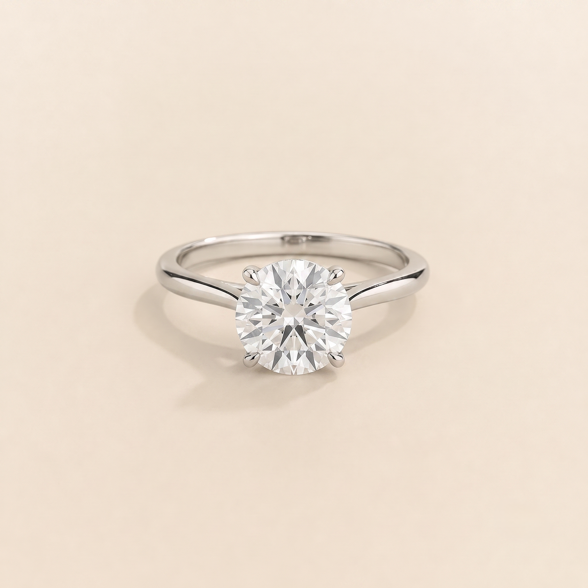 Kissen Ring in white gold, set with a round cut Diamond in an east–west setting.