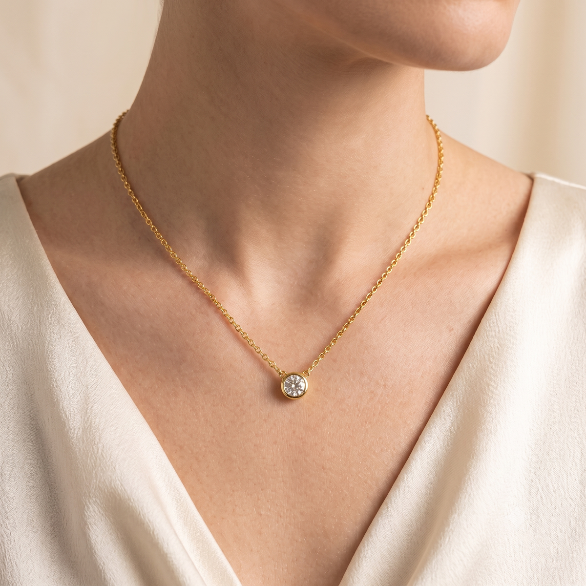 A model is wearing Margo Diamond Round Bezel Set Solitaire Gold Necklace by Juvetti, bespoke jewellery London