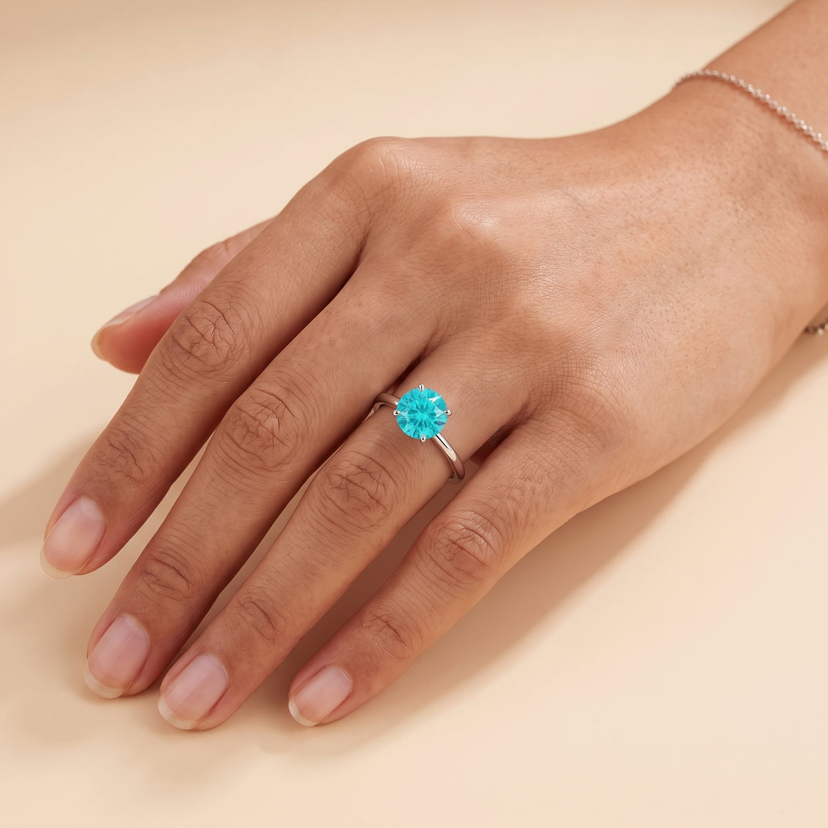 Model wearing the Nina Round Shape Paraiba Sapphire Cathedral Solitaire Ring in White Gold