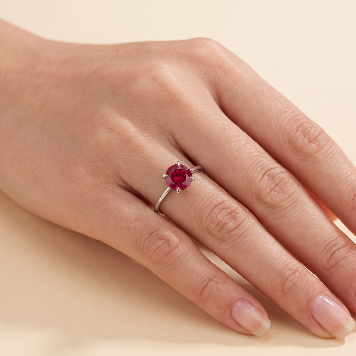 A model is wearing the Nina Round Shape Ruby Cathedral Solitaire Ring in White Gold