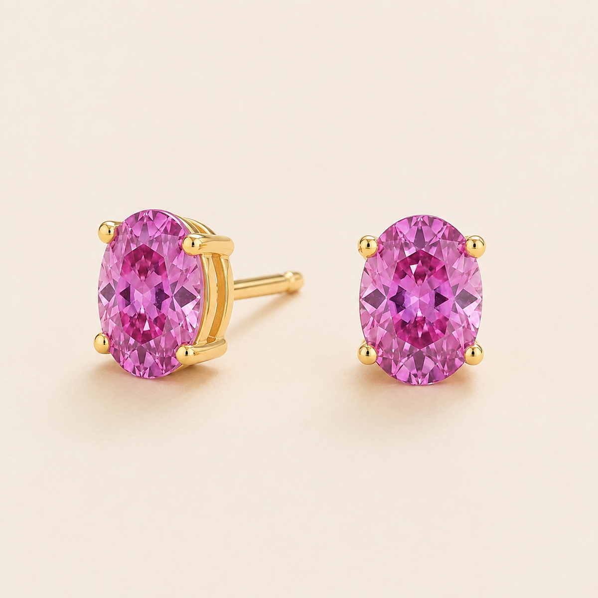 Ovo Vivid Pink Sapphire Oval Solitaire Stud Earrings in Gold Angle View 