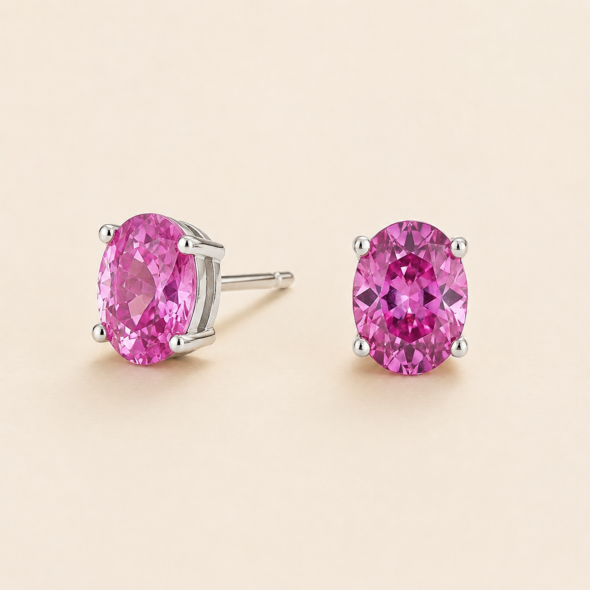 Ovo Vivid Pink Sapphire Oval Solitaire Stud Earrings in White Gold Angle View 