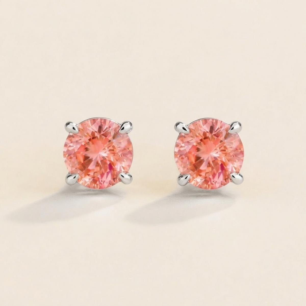 Nina round lab-grown padparadscha sapphire solitaire stud earrings in white gold – front view | Juvetti London