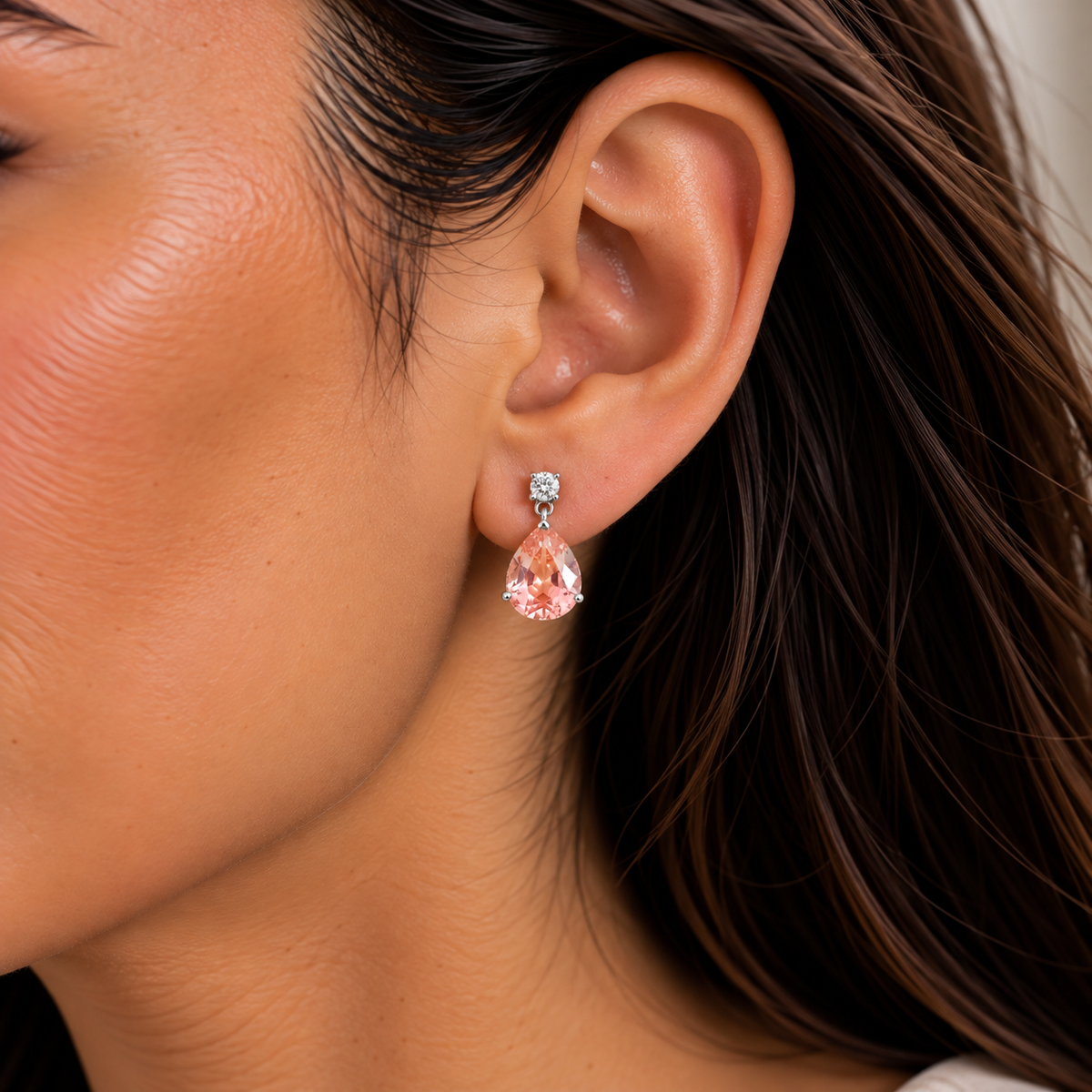 Medium lab-grown Padparadscha sapphire and diamond pear drop earrings in white gold worn on model | Pisa by Juvetti