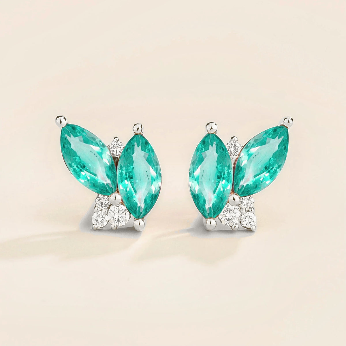 A pair of white gold earrings with marquis shaped paraiba and round diamonds.