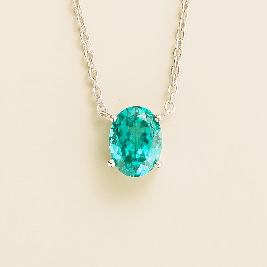 A white gold necklace with oval Paraiba solitaire pendant