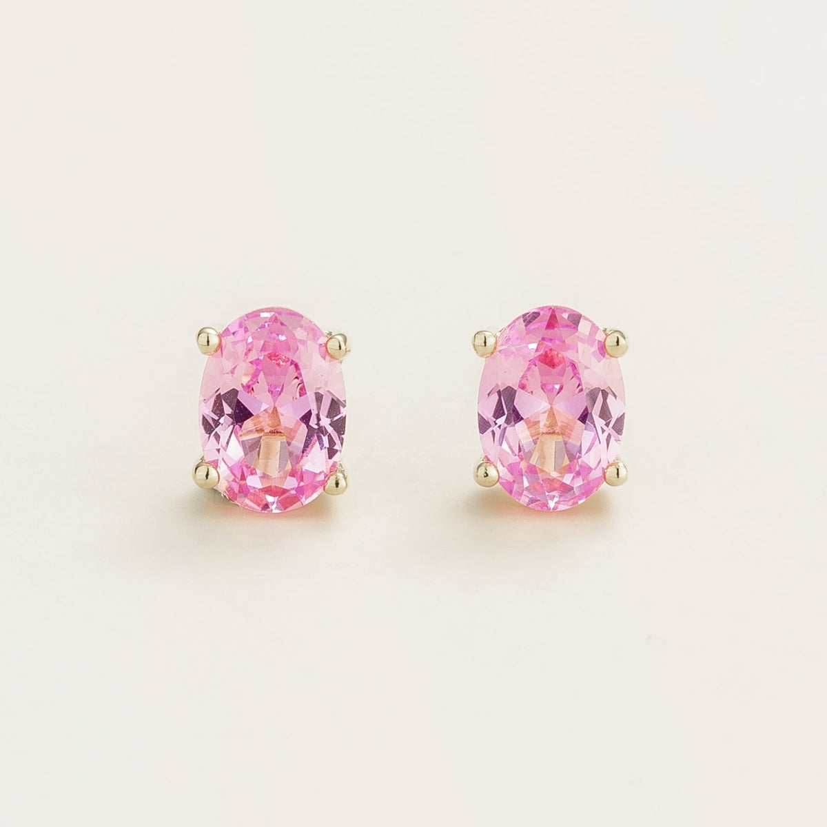 A pair of white gold stud earrings set with pink sapphires.