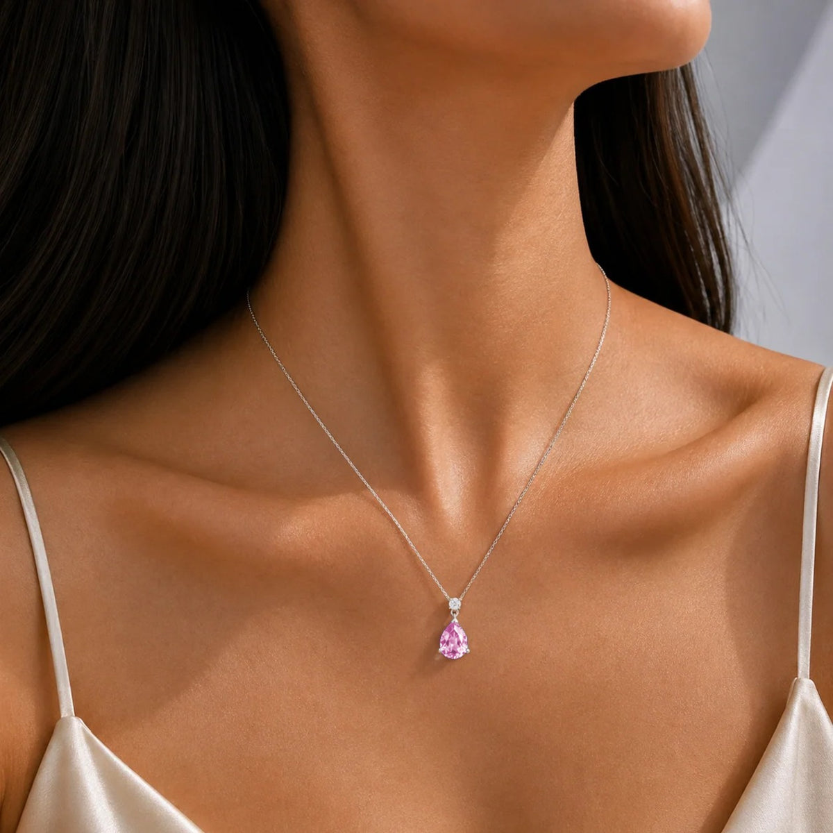 Model wearing a lab-grown pastel pink sapphire and diamond pear drop pendant necklace in white gold, medium | Pisa by Juvetti