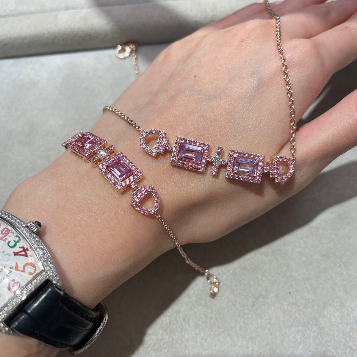 Ciceris pink sapphire Art Deco halo bracelet in white gold, two emerald-cut lab-grown sapphires with diamonds, worn on the wrist | Juvetti London