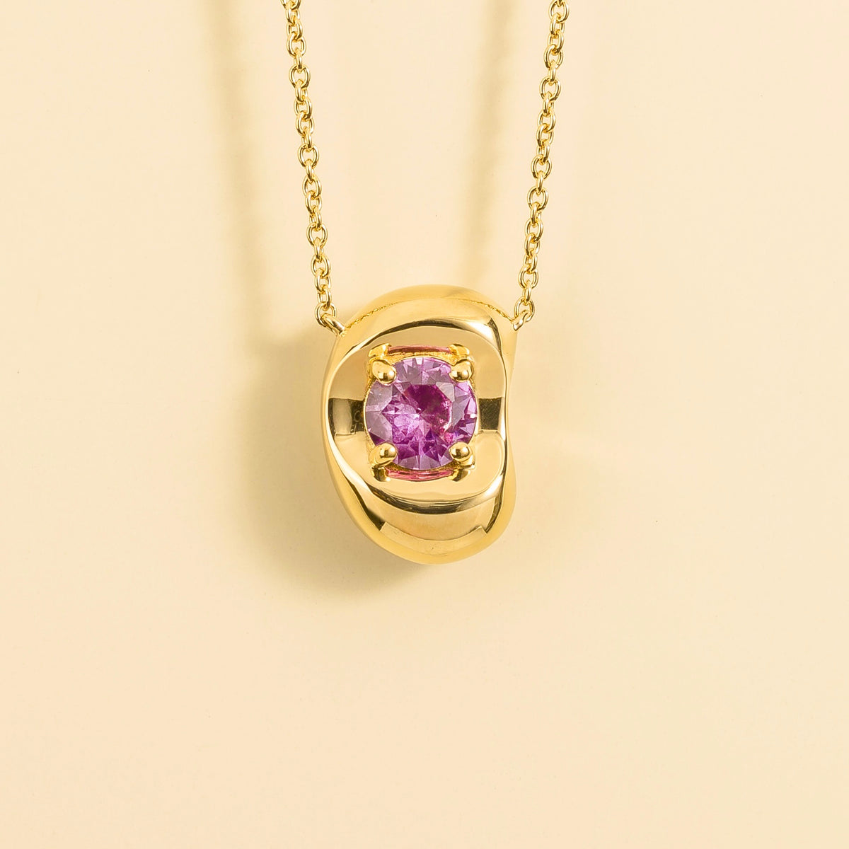 Fava round lab-grown pink sapphire pendant necklace in gold, sculpted pebble setting, front view | Juvetti London