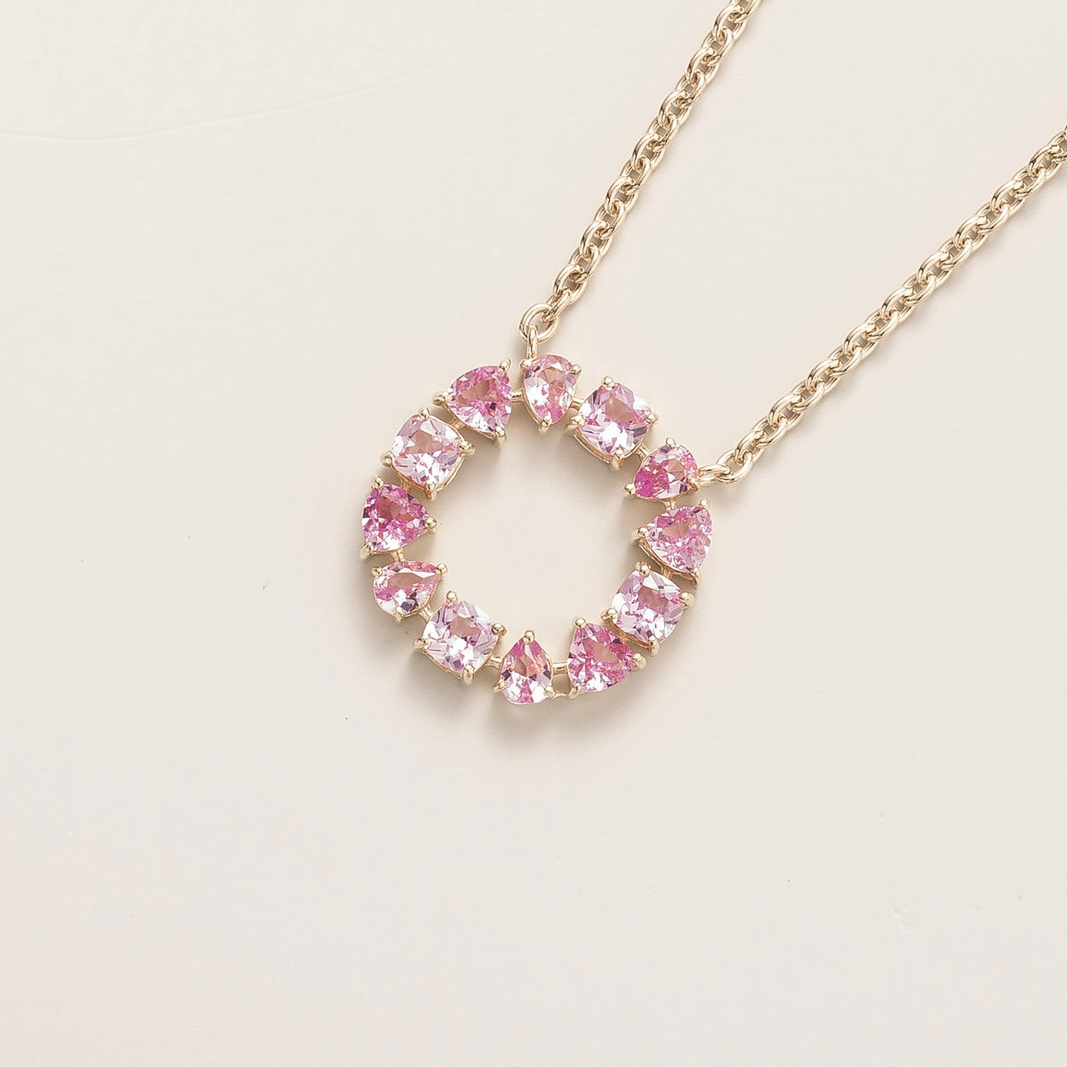 Glorie pink sapphire open circle pendant necklace in white gold, mixed-cut lab-grown sapphires, angled view | Juvetti London