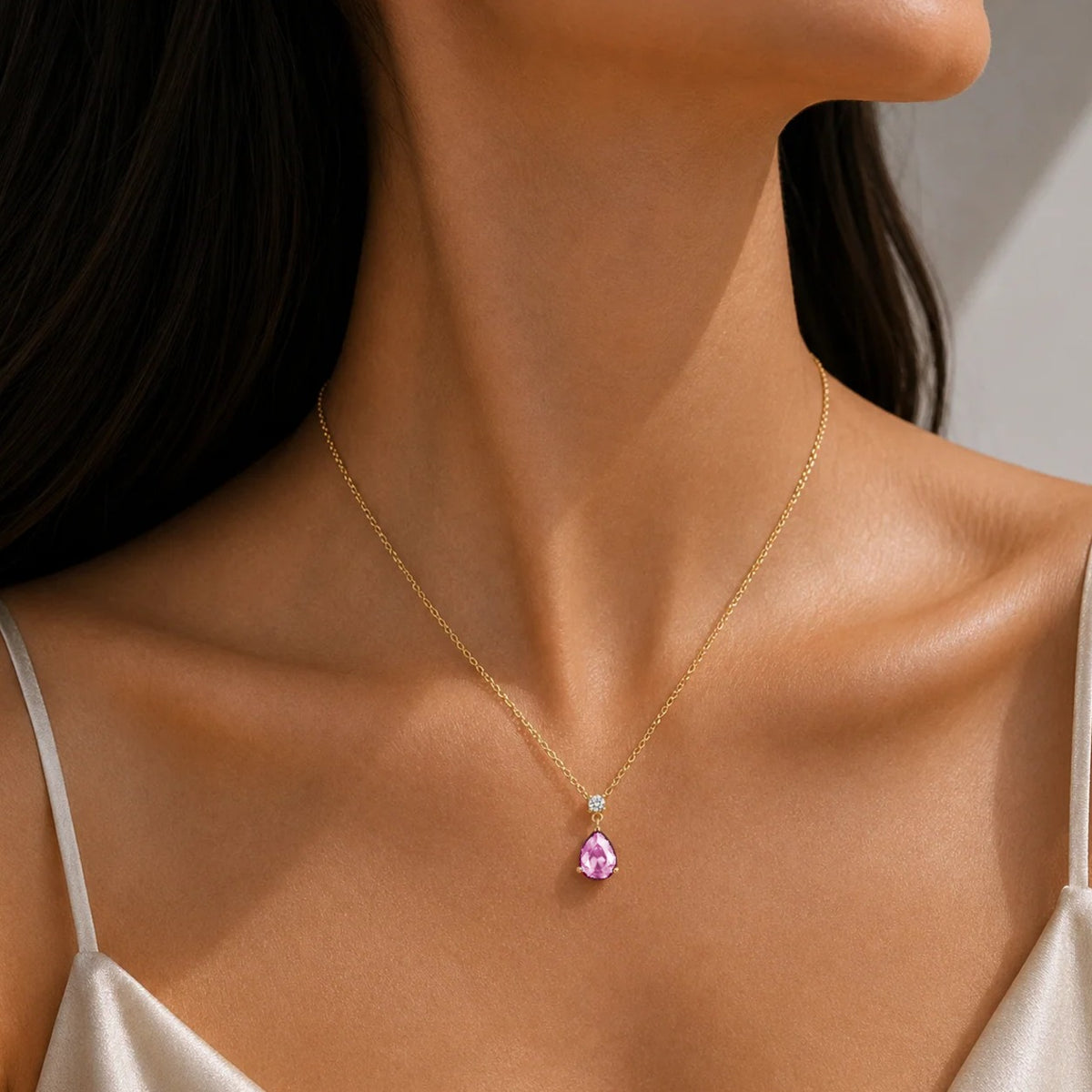 Model wearing a lab-grown pink sapphire and diamond pear drop pendant necklace in gold, medium | Pisa by Juvetti