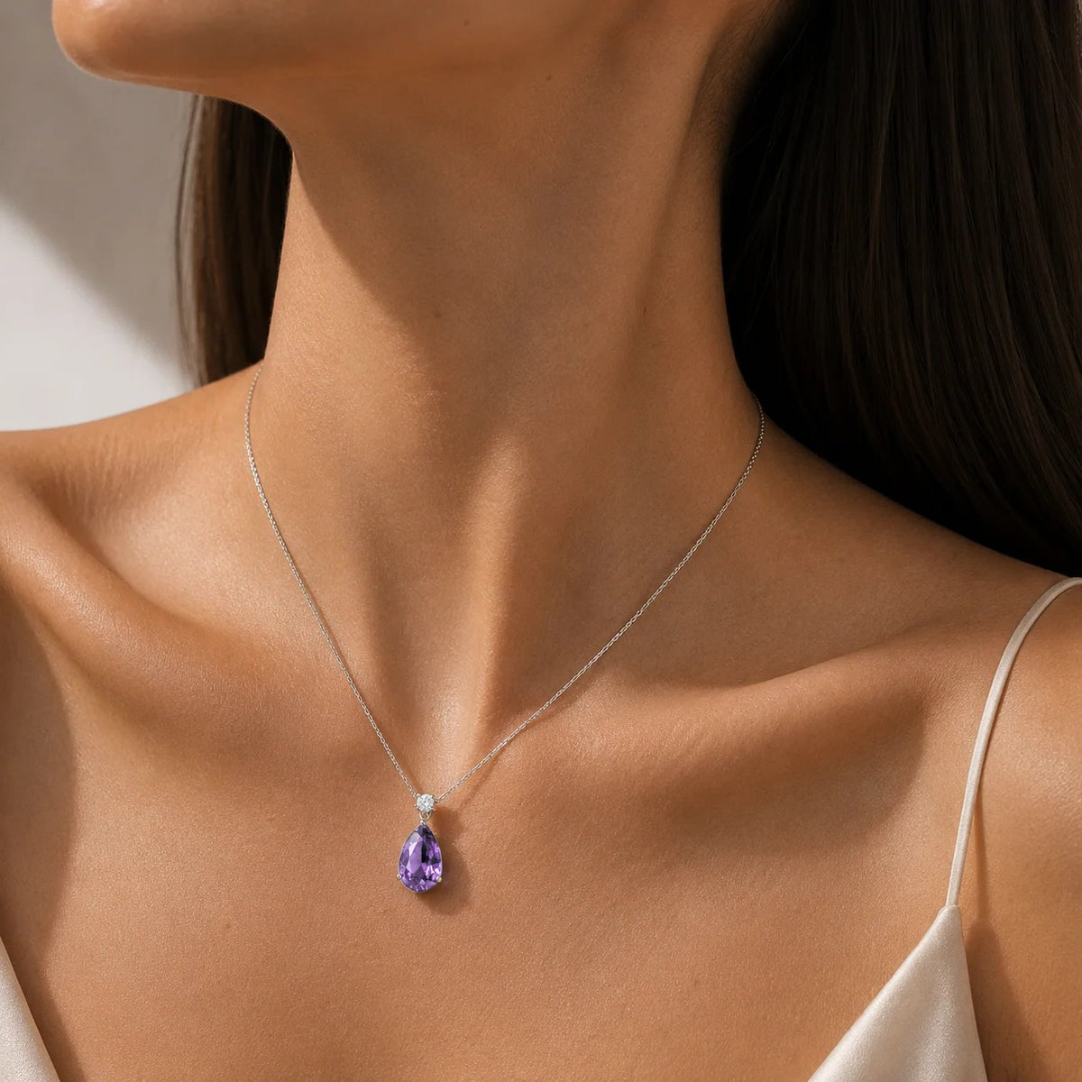 Model wearing the Pisa large purple sapphire pear drop pendant necklace in white gold