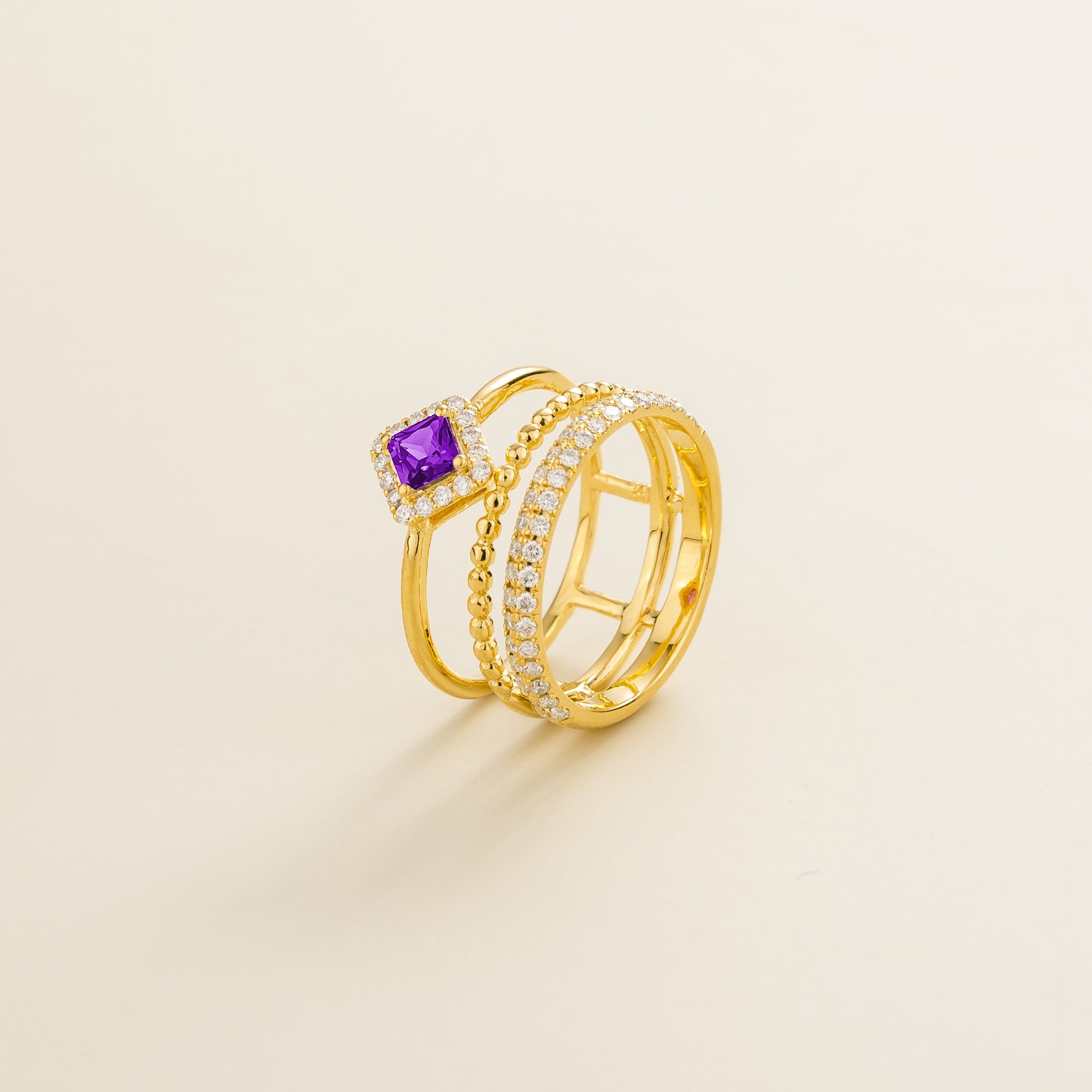 Side view of the Amici purple sapphire ring in gold showing the round purple sapphire, Juvetti London