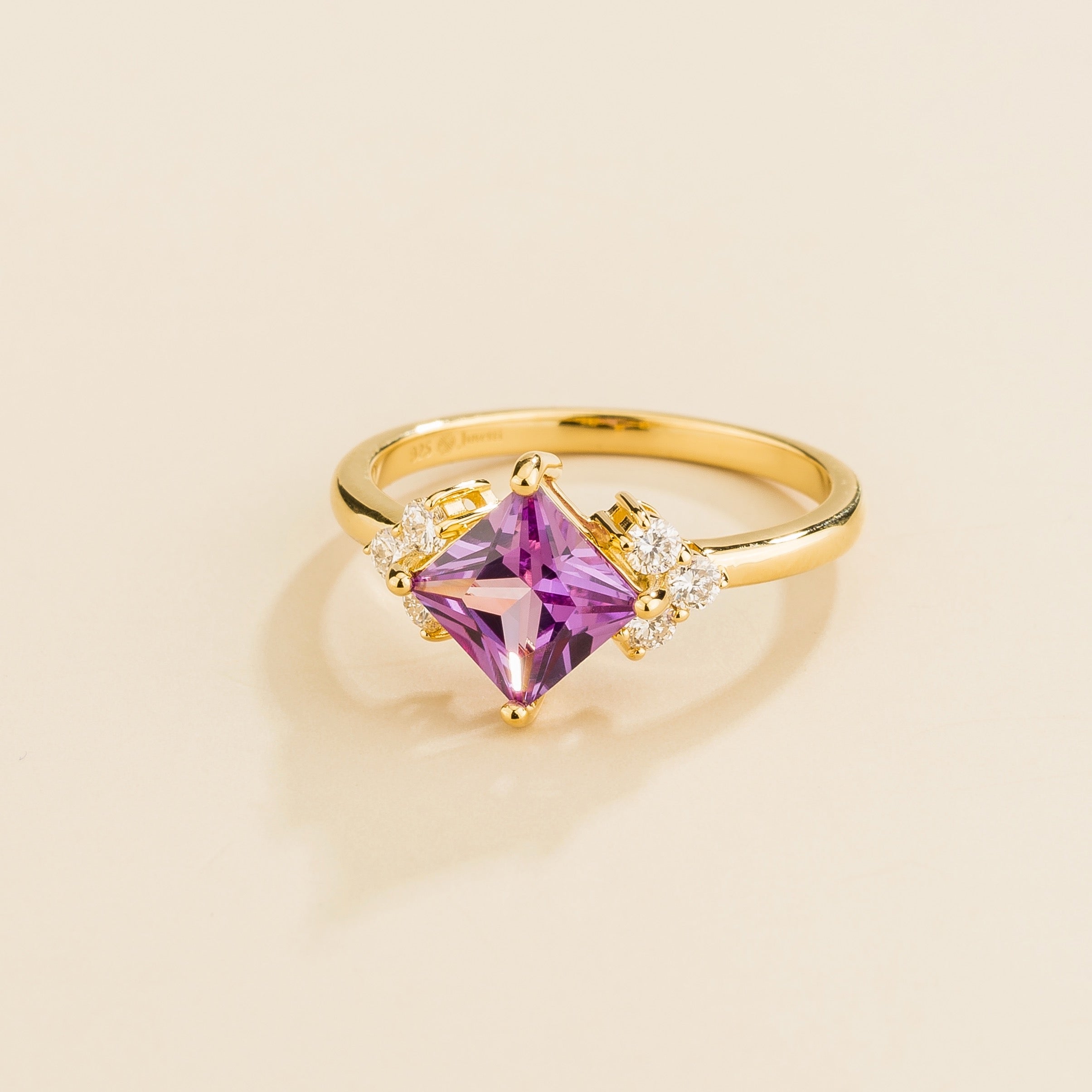 Side view of the Amore purple sapphire ring in gold showing the princess purple sapphire, Juvetti London
