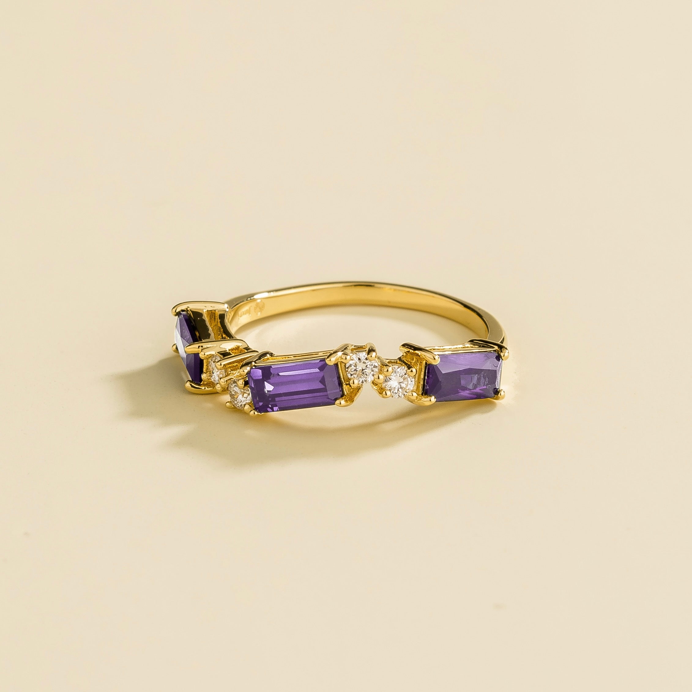Side view of the Forma purple sapphire ring in gold showing the baguette purple sapphire, Juvetti London