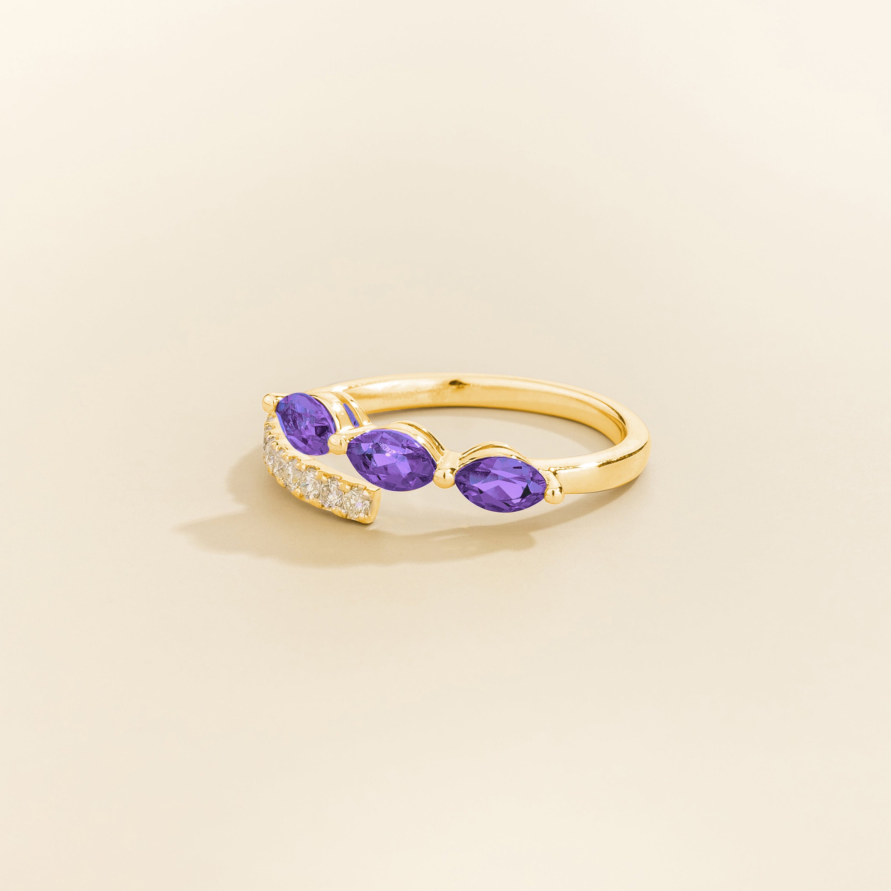 Side view of the Sava purple sapphire ring in gold showing the round purple sapphire, Juvetti London