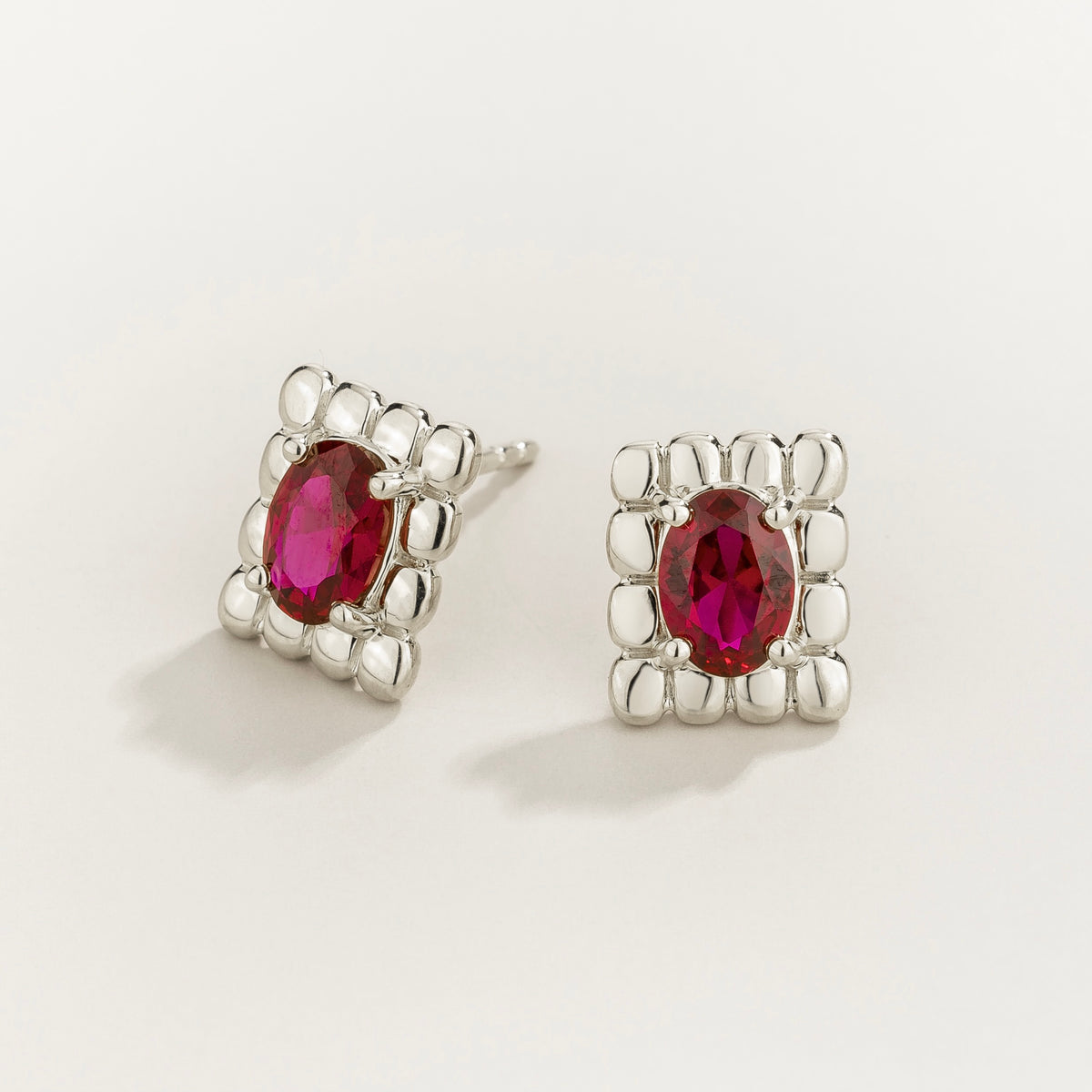 Fondi oval lab-grown ruby sculpted stud earrings in white gold – angle view | Juvetti London