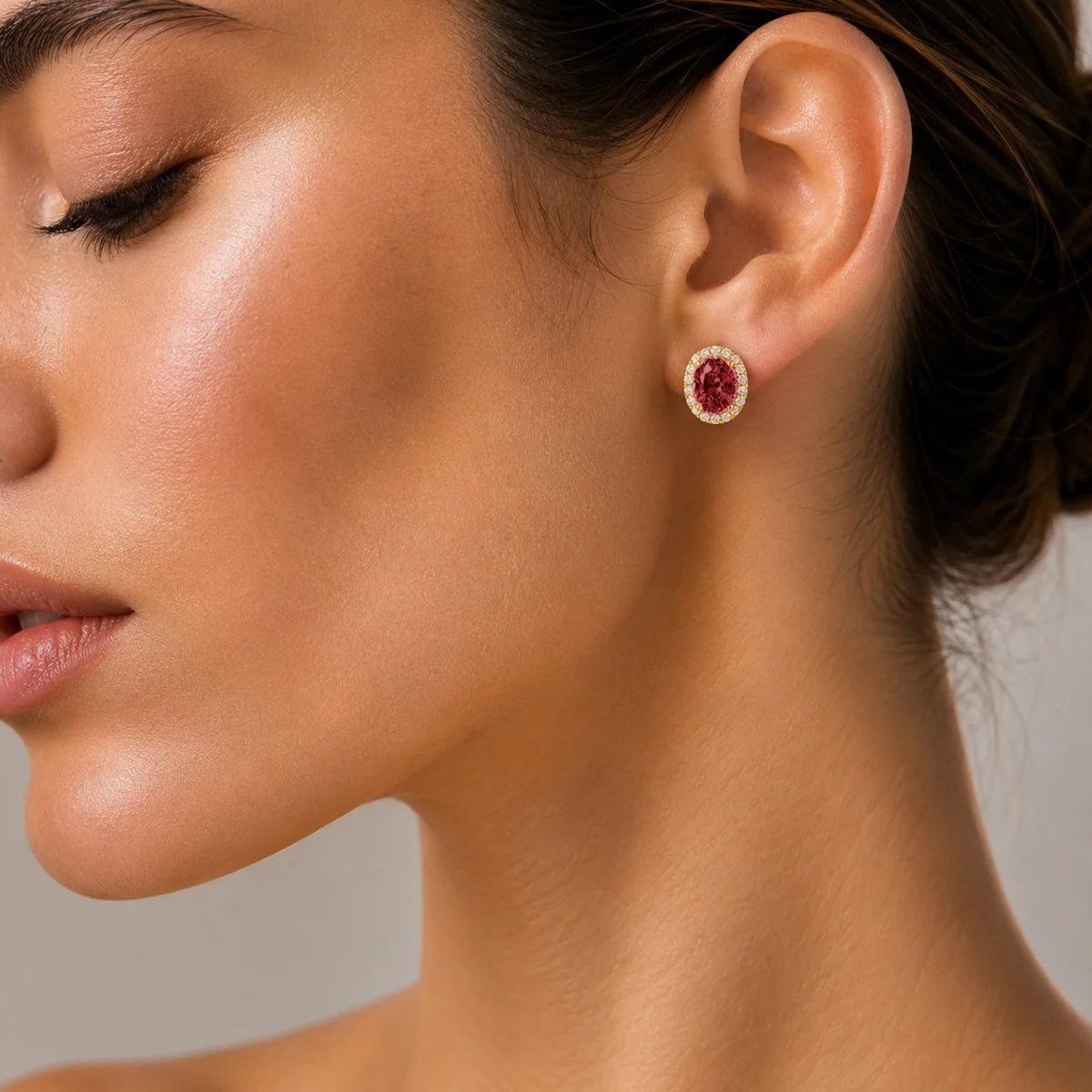 Model wearing lab-grown ruby and diamond oval halo stud earrings in gold | Mina by Juvetti