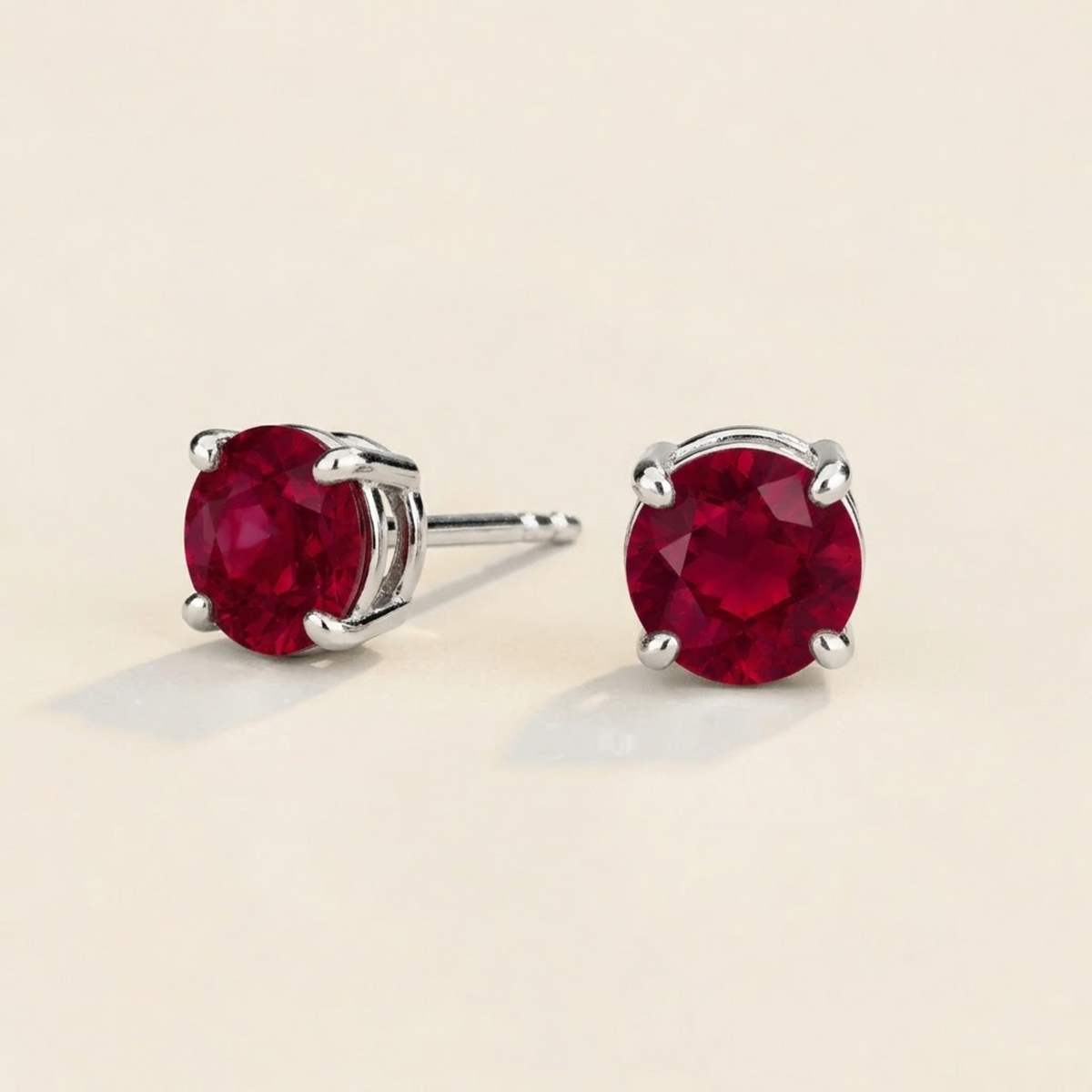 Nina round lab-grown ruby solitaire stud earrings in white gold – angled view | Juvetti London