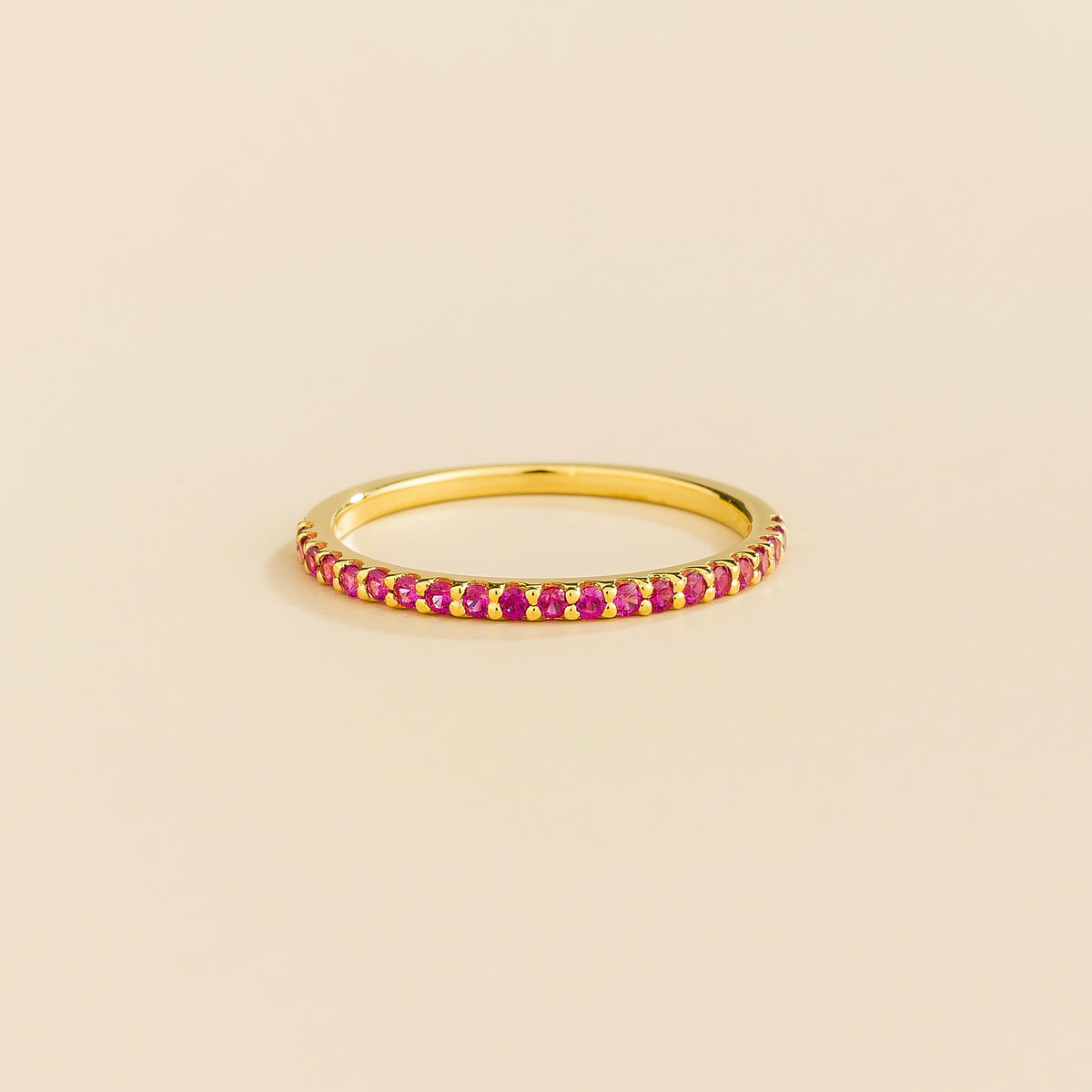 Juvetti yellow gold half eternity band set with round lab-grown ruby gemstones.