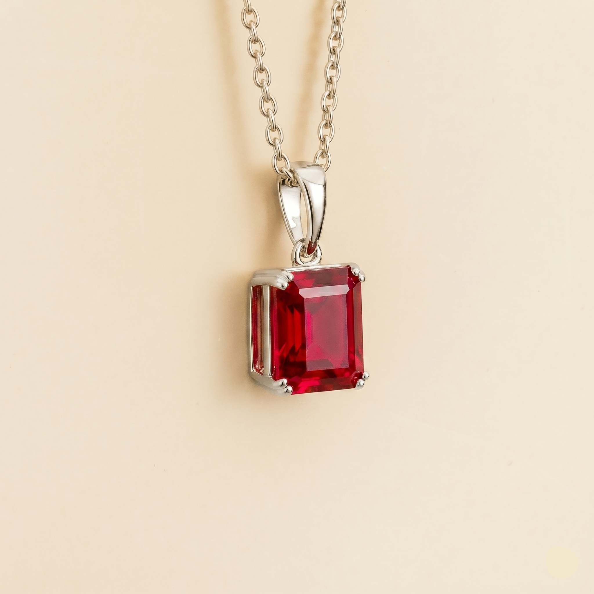 Side view of the emerald cut ruby on the Thamani necklace in white gold, Juvetti jewellery