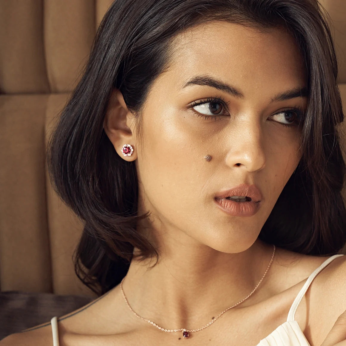 A model wearing Melba hexagon earrings and pear drop Pisa necklace set with lab grown diamond, ruby and pink sapphire gem stones.