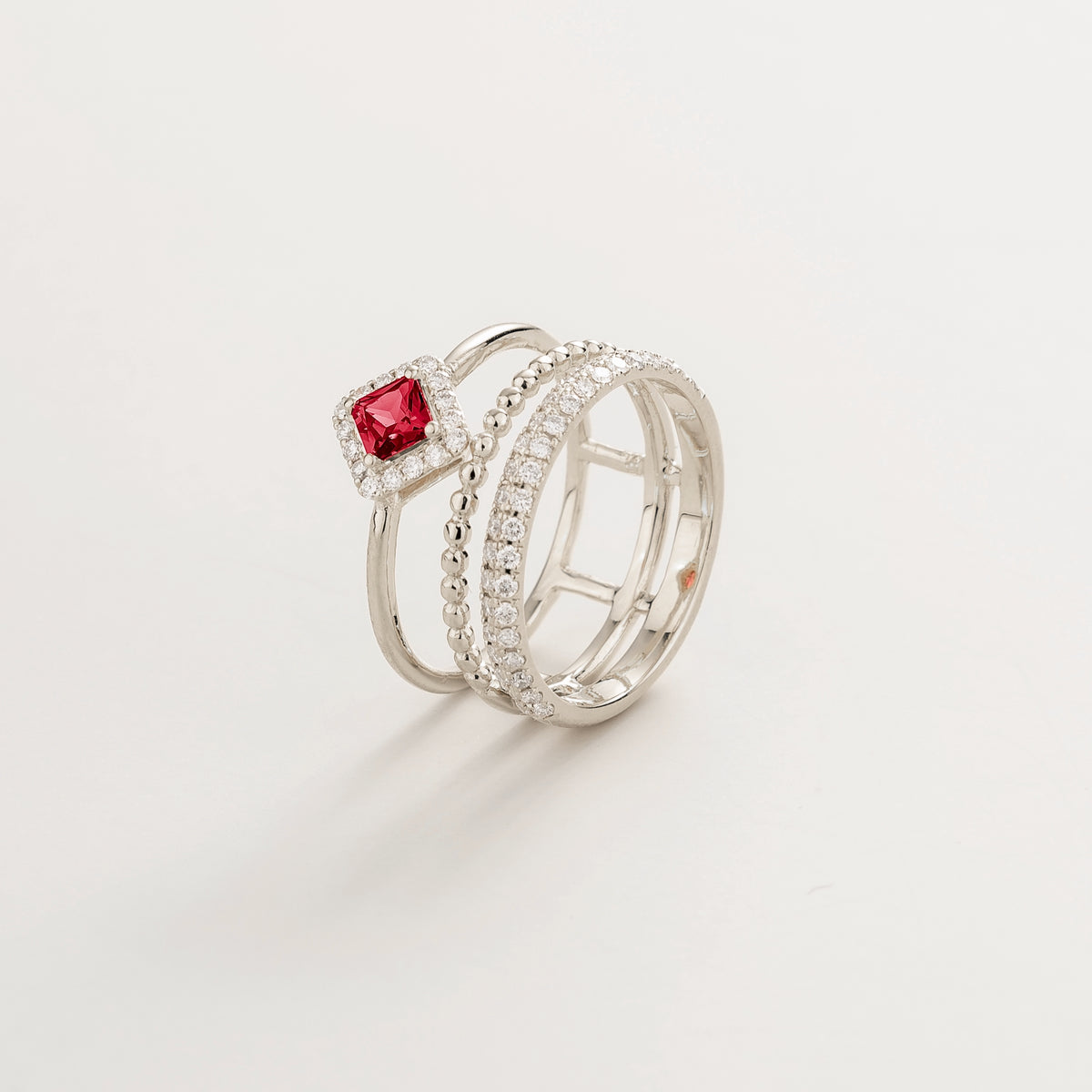 Amici triple-band stacking ring in white gold, princess-cut lab-grown ruby in a diamond halo with beaded and pavé bands, side view | Juvetti London