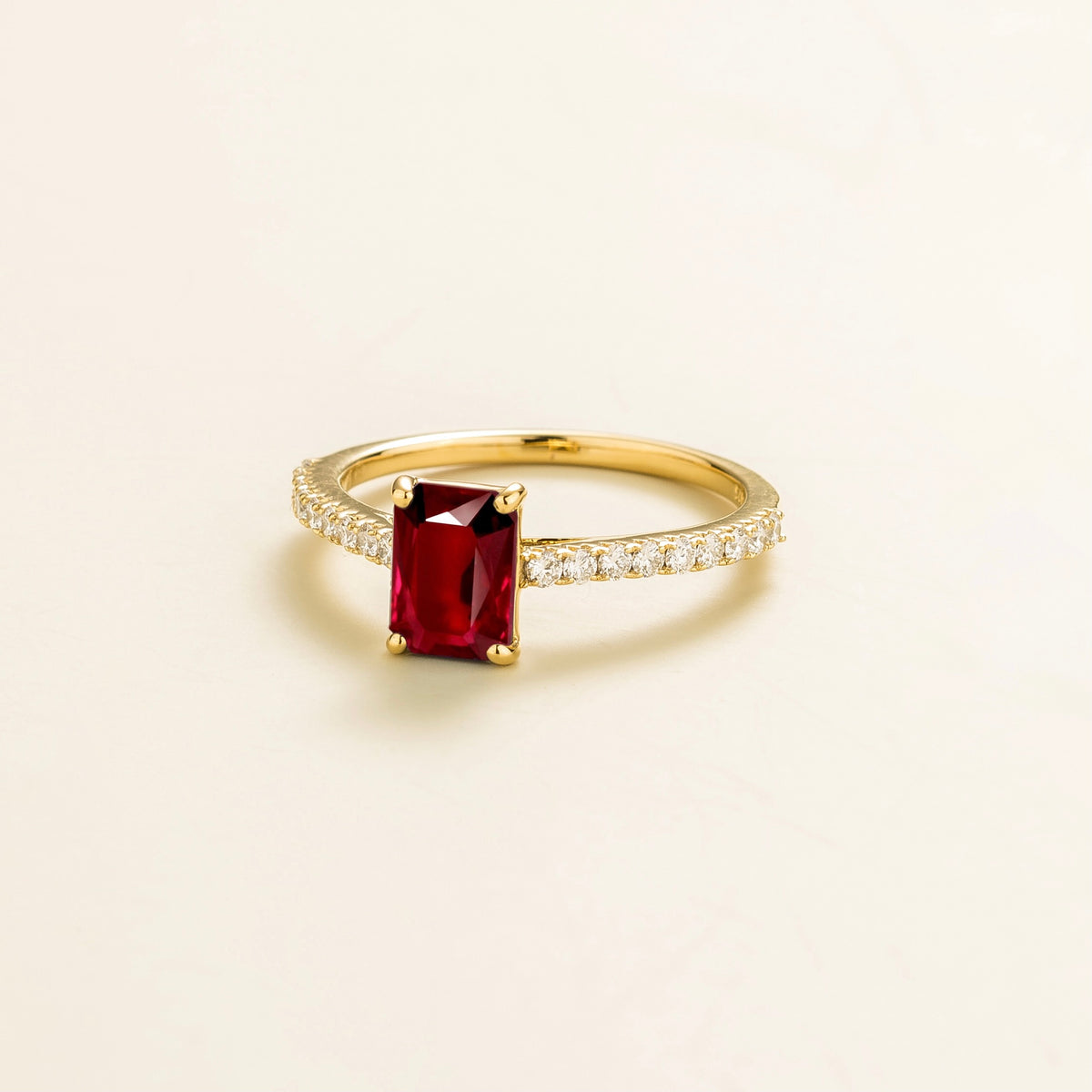 Chelle emerald-cut ruby and diamond pavé solitaire ring in gold – angle view