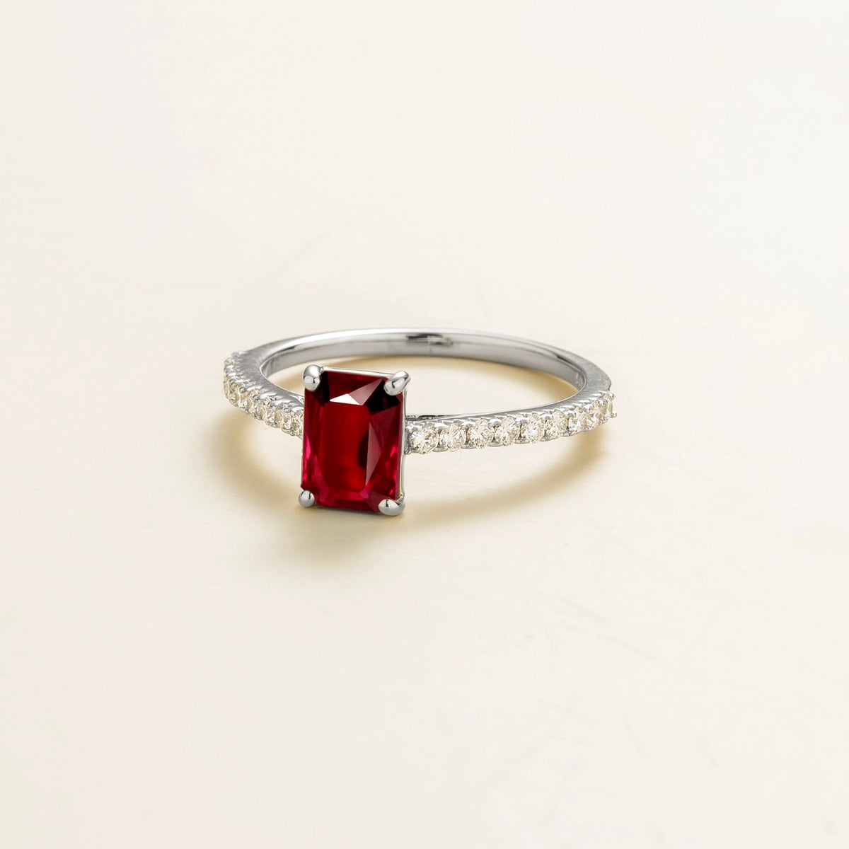 Chelle emerald-cut ruby and diamond pavé solitaire ring in white gold – angle view