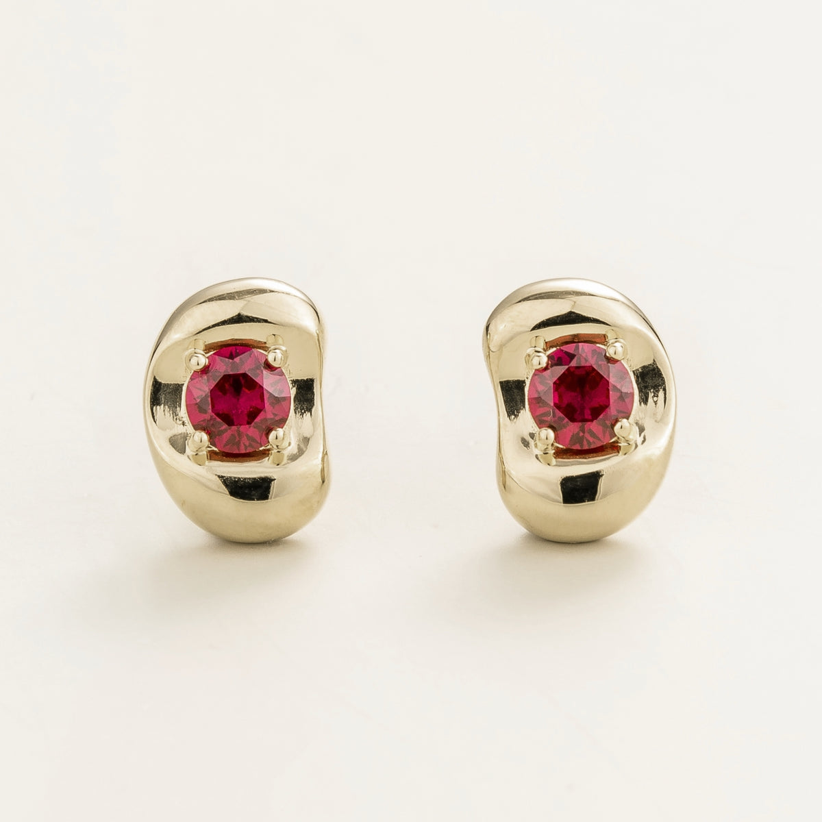 Fava round lab-grown ruby stud earrings in white gold, sculpted pebble setting, front view | Juvetti London