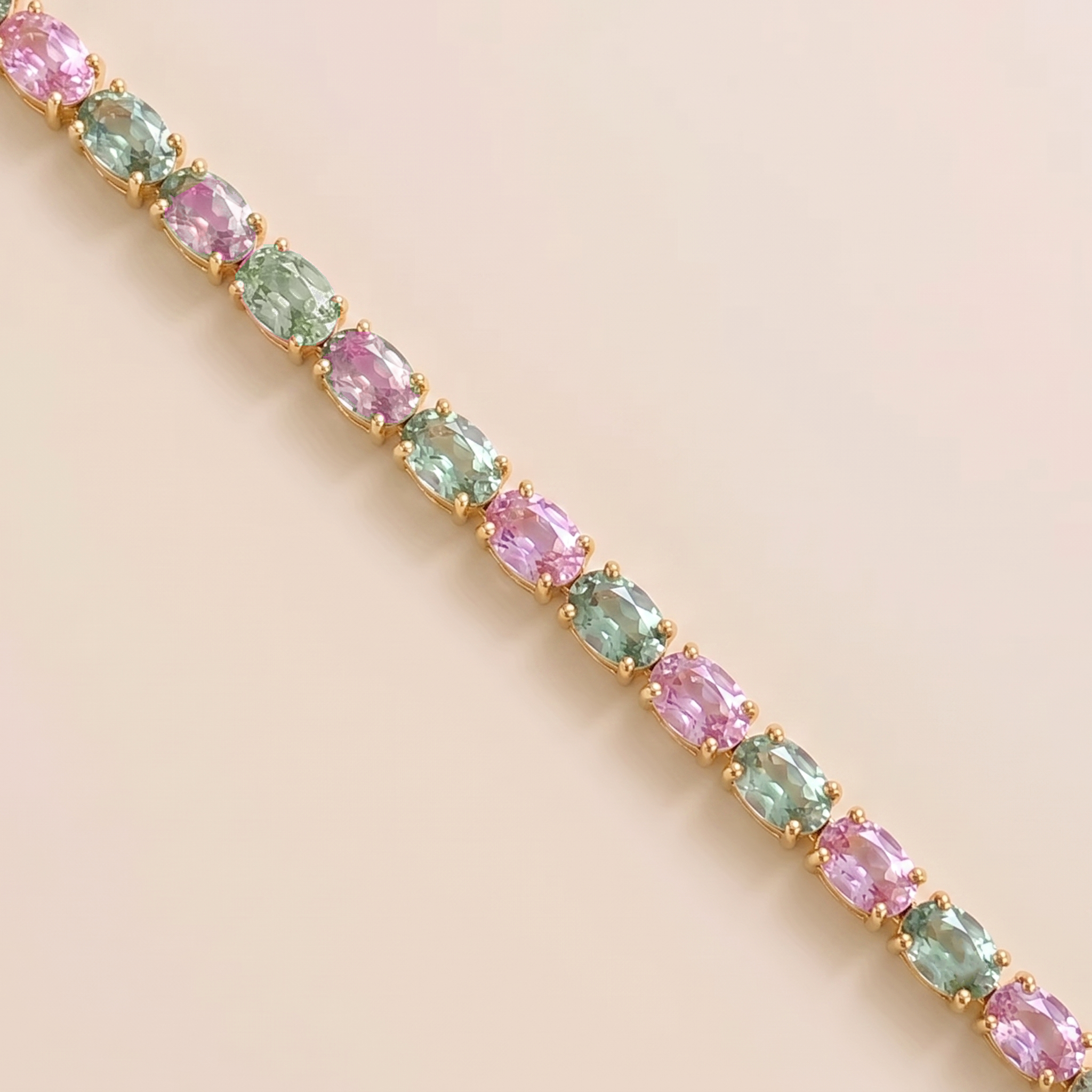 Oval lab-grown pastel pink and green sapphire tennis bracelet in gold | Juvetti London.