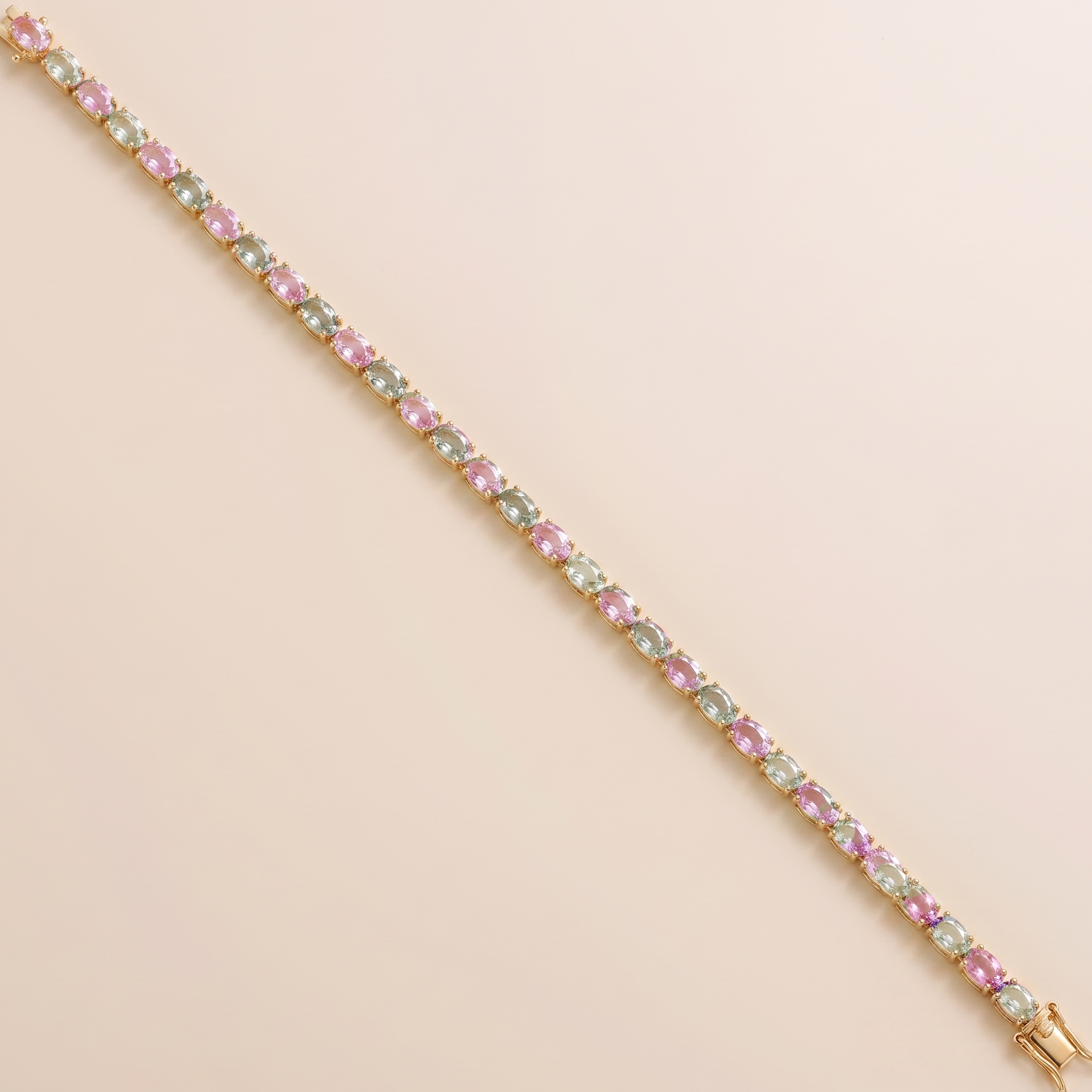 Oval lab-grown pastel pink and green sapphire tennis bracelet in gold | Juvetti London.